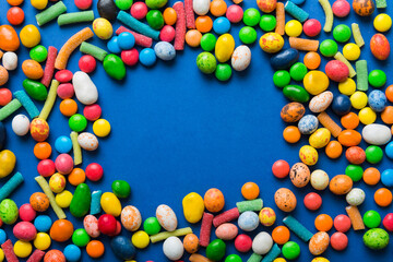 Mixed collection of colorful candy, on colored background. Flat lay, top view. frame of colorful chocolate coated candy