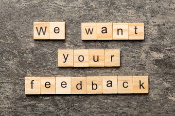 We want your feedback word written on wood block. We want your feedback text on cement table for...