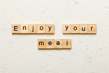 Enjoy your meal word written on wood block. Enjoy your meal text on cement table for your desing, concept