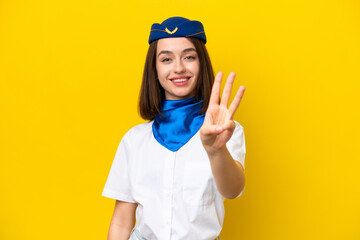 Airplane stewardess Ukrainian woman isolated on yellow background happy and counting three with fingers