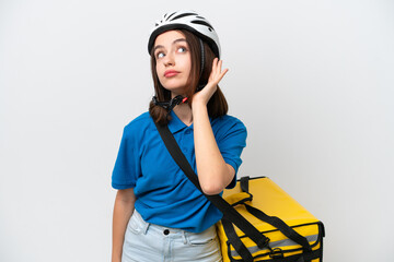 Young Ukrainian woman with thermal backpack isolated on white background listening to something by putting hand on the ear