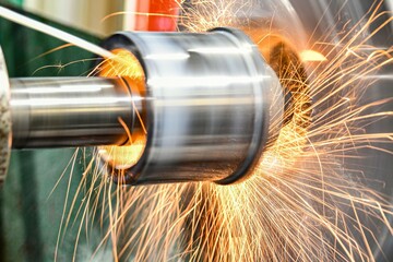 The abrasive wheel removes the excess metal layer, sparks fly to the sides.