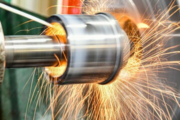 Fototapeta premium The abrasive wheel removes the excess metal layer, sparks fly to the sides.