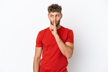 Young caucasian handsome man isolated on white background showing a sign of silence gesture putting finger in mouth