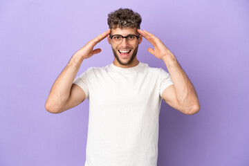 Delivery caucasian man isolated on purple background with surprise expression