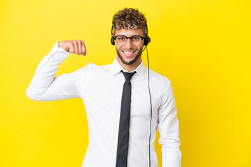 Telemarketer blonde man working with a headset isolated on yellow background doing strong gesture