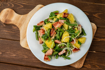 Liege potato salad with beans and ham and bacon, traditional Belgian salad in a white plate on a...