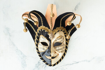 Venetian carnival mask on the white marble background. Full-head black characteristic mask with...