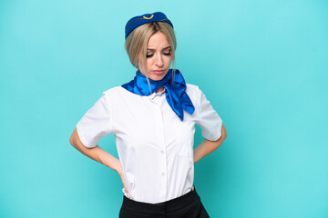 Airplane blonde stewardess woman isolated on blue background suffering from backache for having made an effort