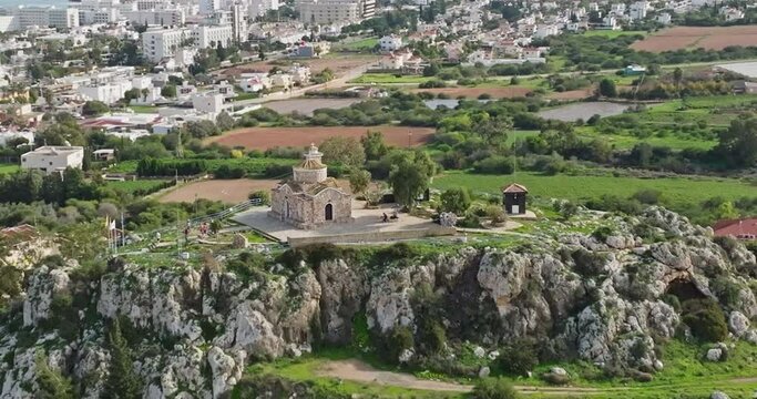 Aerial view of the church on the mountain in Cyprus. A beautiful landscape with a religious building. Cityscape of buildings and villages on the seashore. High quality 4k footage