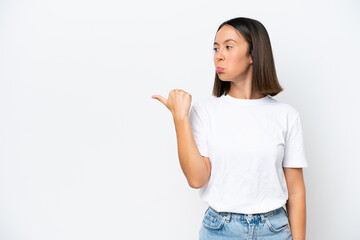 Young caucasian woman isolated on white background unhappy and pointing to the side