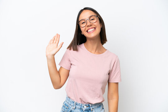 Young caucasian woman isolated on white background saluting with hand with happy expression