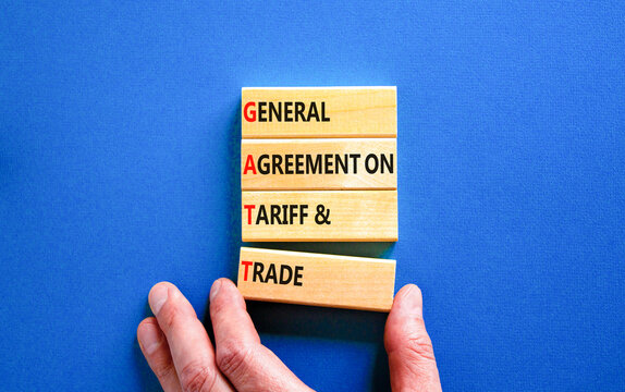 GATT symbol. Concept words GATT general agreement on tariff and trade on wooden block on beautiful blue background. Business GATT general agreement on tariff and trade concept. Copy space.