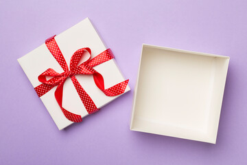 Open gift box on color background, top view