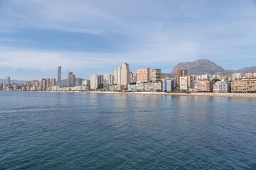 Fototapeta premium Landscape of the city of Benidorm in front of the Mediterranean coast. City with skyscrapers on the beachfront. View of the city of Benidorm from the sea. 