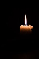 Isolated glowing candle in a black background.