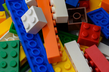 Multi-colored toys made of plastic cubes and bricks, children's constructor.Top view.