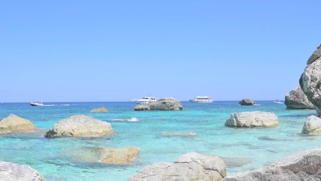 Blue beach in Sardinia. Italian coast, elite resorts. BLUE SKY AND CLEAR WATER and white small stones. High quality 4k footage. Vertical
