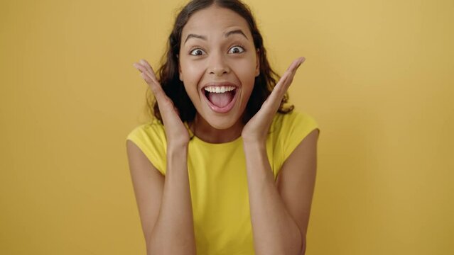 Young african american woman standing with surprise expression over isolated yellow background