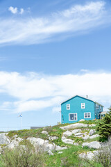 landscape turquoise house on the hill with Nova Scotia flag on the ground near sea beach Peggys cove Halifax Nova Scotia, Canada