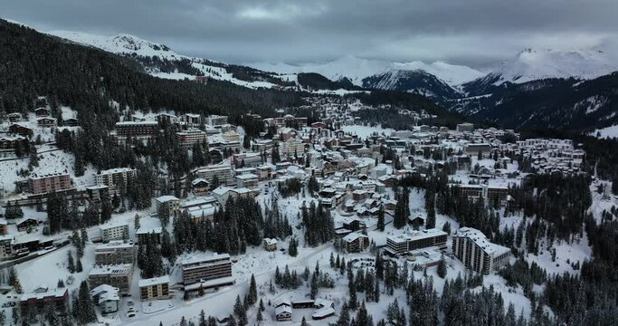 Aerial tracking shot of an early morning snow covered ski town in Switzerland
