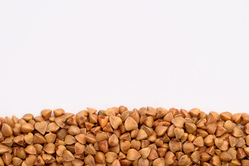 Close-up of buckwheat on a white background. Hypoallergenic pillow filling. Prevention of anemia.