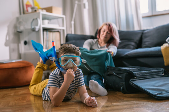 Impatient Young Boy Try’s On Diving Mask Before His Trip With Mom