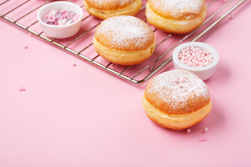 Donuts Doughnuts with Icing Sugar and Sprinkles on Pink Background