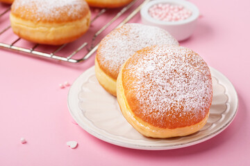 Obraz na płótnie Canvas Donuts Doughnuts with Icing Sugar and Sprinkles on Pink Background