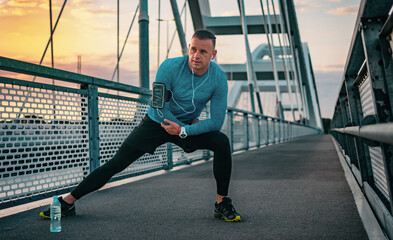 Morning run over the bridge. Fitness, sport and recreation. Sports man jogging and listen the music.