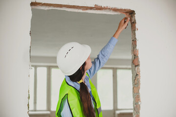 female Industrial engineer in High-Visibility vest check work in construction site