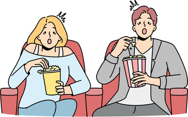 Couple eat popcorn sitting in cinema