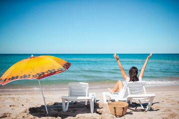 Young beautiful woman relaxing at white sand tropical beach 