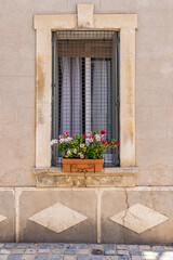 Fototapeta na wymiar Flowers in a window box on an old building in Provence.