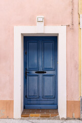 Fototapeta na wymiar Blue painted door in a pink stucco wall.