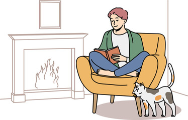 Happy man relax in chair near fireplace with book