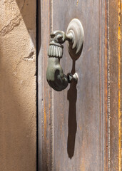 Obraz premium Brass door knocker in the shape of a hand.