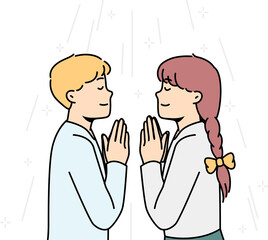Boy, girl pray to God facing each other in church.
