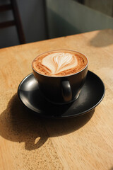 a cup of late coffee with flower shape design on top at cafe 
