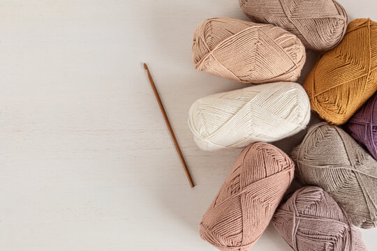 Craft knitting hobby background with yarn in natural colors. Recomforting hobby to reduce stress for cold fall and winter weather. Mock up, copy space, top view