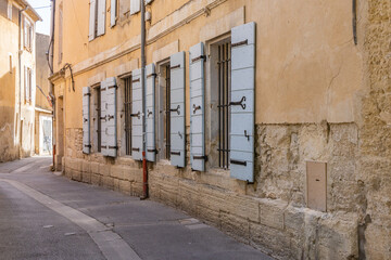 Windows with wooden shutters along a narrow street.