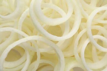 Fresh ripe onion rings as background, top view