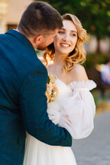 Fototapeta premium the groom gently hugs and kisses the bride.