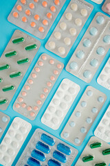 Pharmaceutical drugs, antibiotics, pills. Colorful pills on a blue background, capsule pills