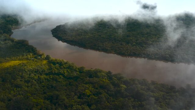 Wide aerial view in a jungle on top the clouds showing a river in the jungle of guaviare in the interior of colombia 4k