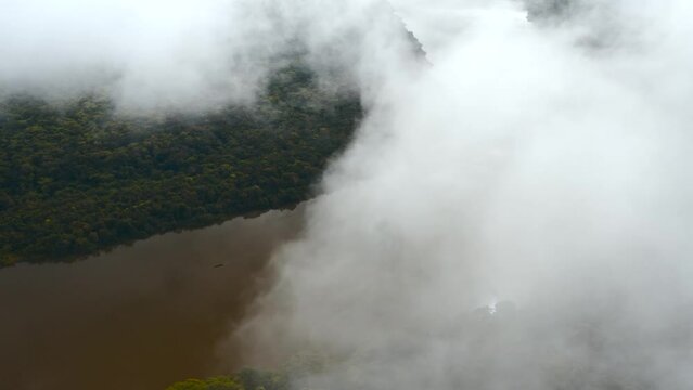 Wide aerial view in a jungle on top the clouds over a river in the jungle of guaviare in the interior of colombia 4k