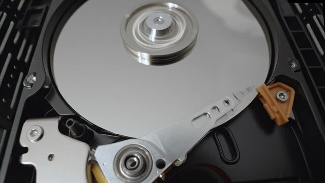Hard drive disk (HDD) inside computer. Mechanical parts of hardware moving inside.