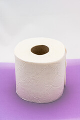 Roll of toilet paper on purple table.