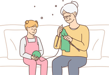 Little girl; child knitting together with grandmother