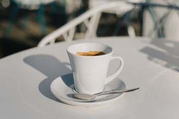 Cup of black coffee on a table in a street cafe.